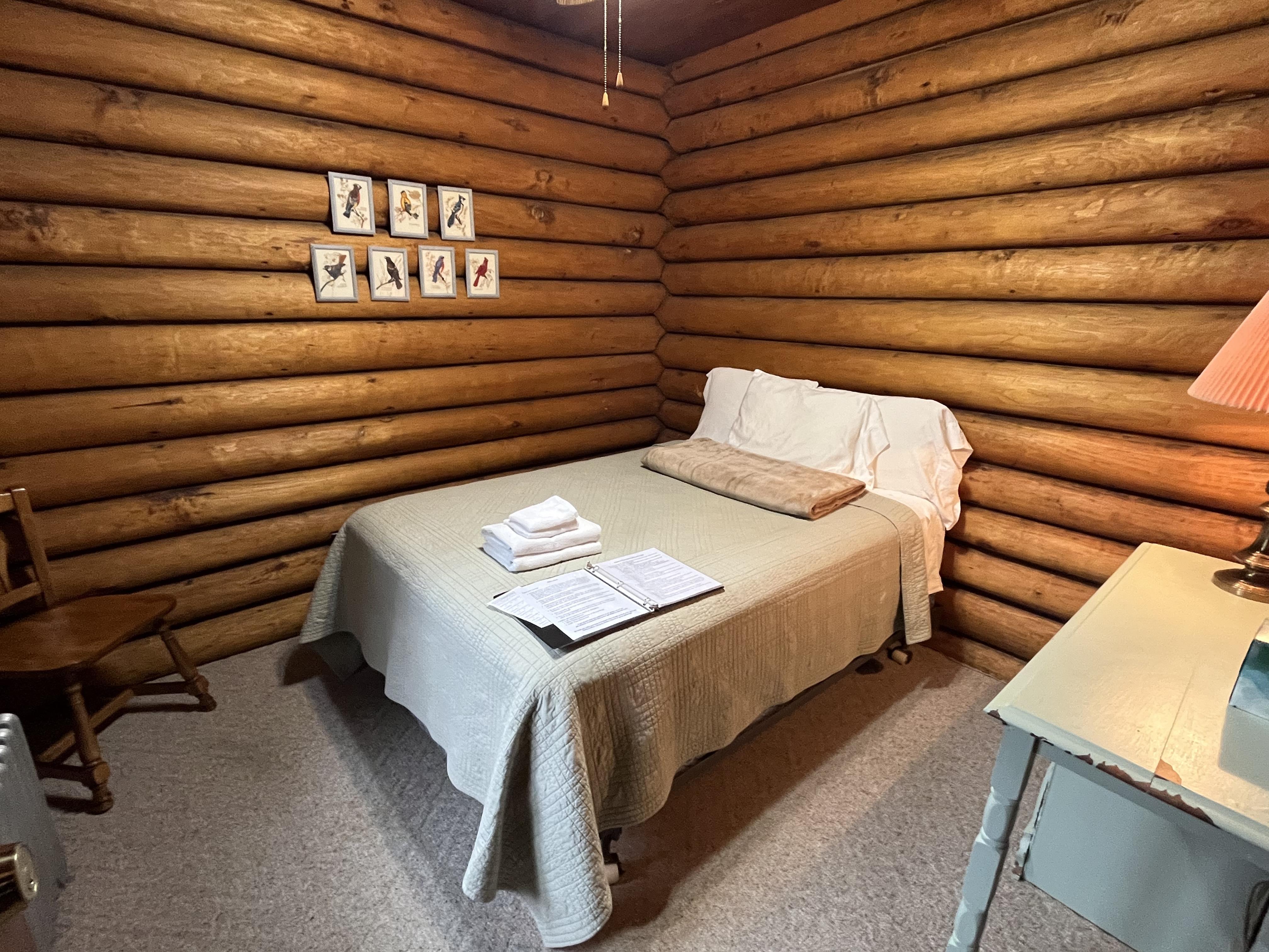 Log Lodge room with log walls and cozy bedding
